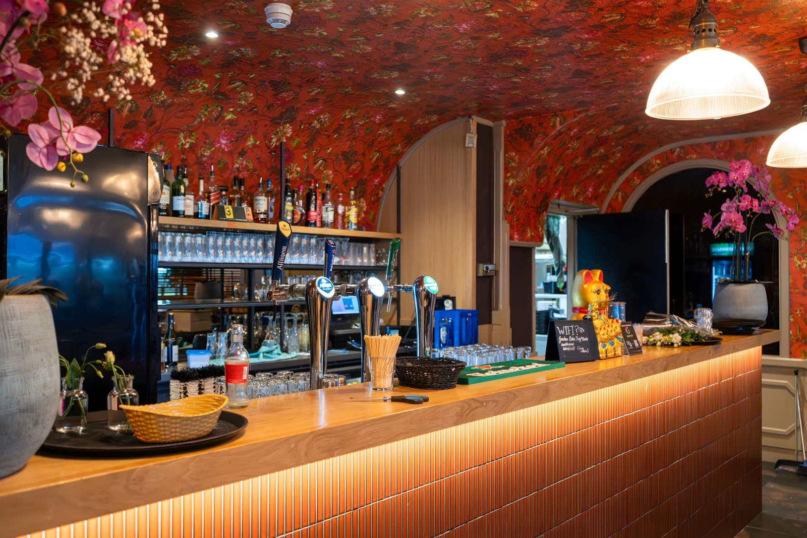 De bar van Teppan met verlichte voorkant, orchideeën en bloemenbehang