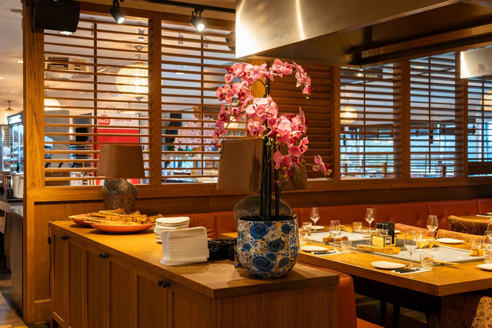Een roze orchidee in een blauw-witte pot op de bar